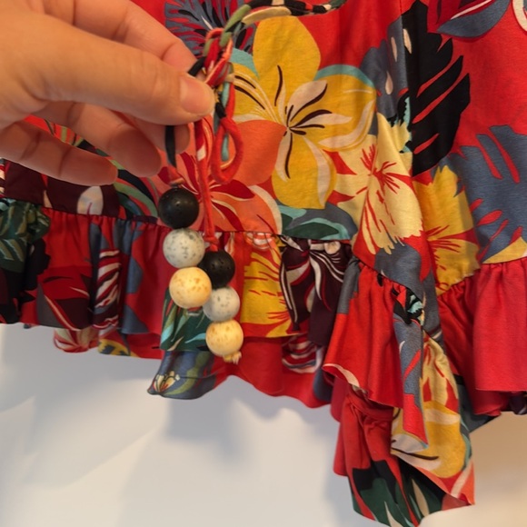 Used short romper 
Ruffles on neck line
Trim ruffles
Flower/tropical print - Picture 2 of 3